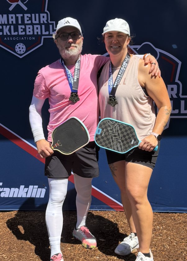 Two pickleball champions with gold medals at a sanctioned tournament