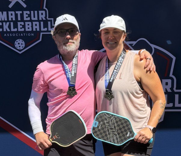 Two pickleball champions with gold medals at a sanctioned tournament
